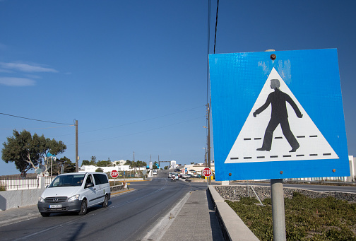Pedestrian Crossing Sign near Pyrgos Kallistis on Santorini, Greece, with a car and driver travelling past