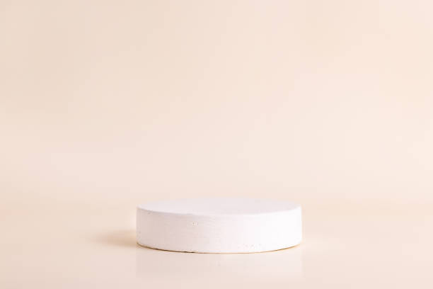 istock White concrete circle shaped pedestal on beige background. Podium mockup background for products. Advertising template. Stone platform. Abstract geometric 1362604533