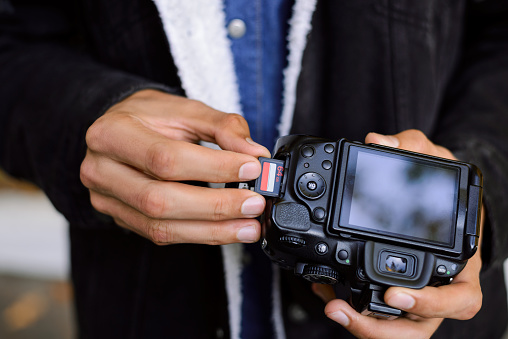 Close-up picture of DSLR camera in the hands of a man