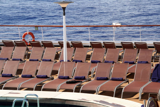 istock Rows of lounge chairs alongside pool on ship desk.  Ocean. 1362608899