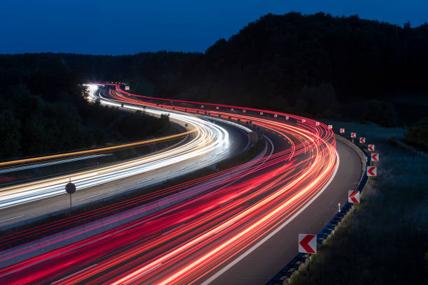 percorsi leggeri per auto sull'autostrada di notte - transportation speed highway traffic foto e immagini stock