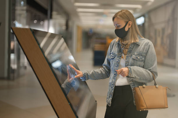 Woman using a self-service terminal in mall. stock photo