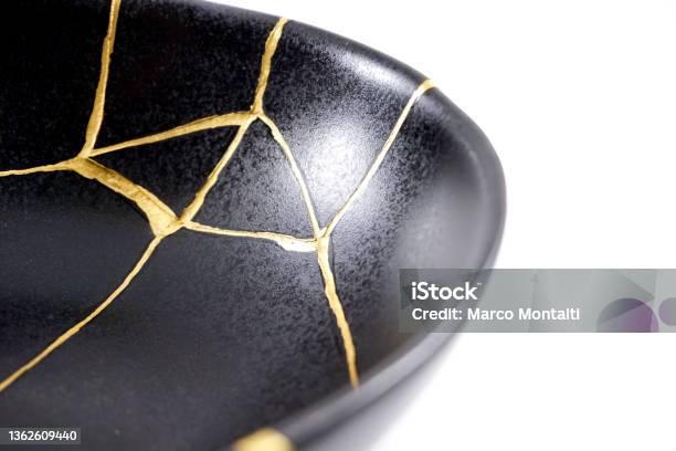 Isolated Black Japanese Kintsugi Bowl Antique Pottery Restored With Gold Cracks Traditional Gold Fixing Method Stock Photo - Download Image Now