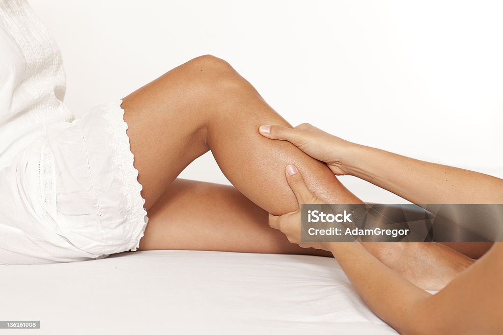 Massage of a female calf muscle Massage of a woman’s calf muscle on white background Alternative Therapy Stock Photo