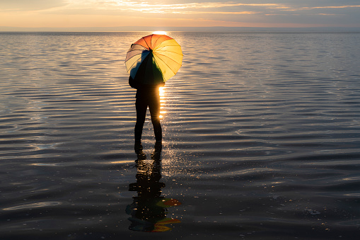tuz gölü manzarasında gün batımını izleyen şemsiyeli kadın. full frame makine ile çekilmiştir