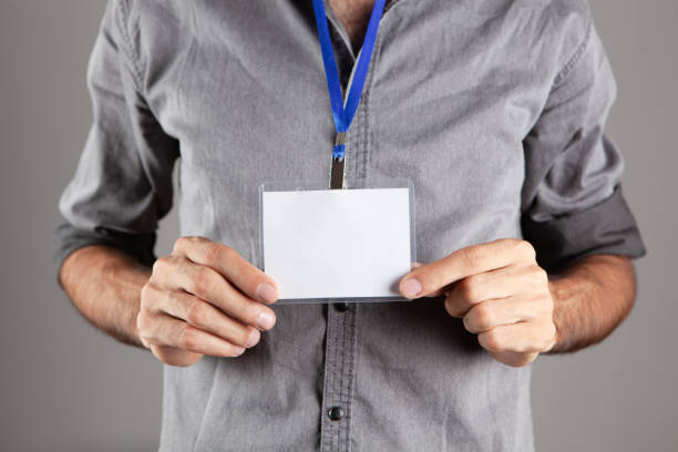istock man holding id tag on gray background 1362615311