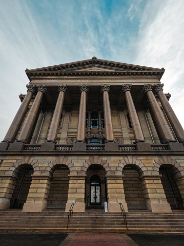 Towering columns and classical architectural features of the Illinois State Capitol Building. View from the North entrance of this majestic building. Set against blue winter skies.