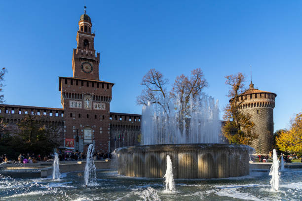 water fountains in front of the castello sforzesco, a medieval castle and famous touristic landmark in milan, italy - milan italy italy castello sforzesco color image imagens e fotografias de stock