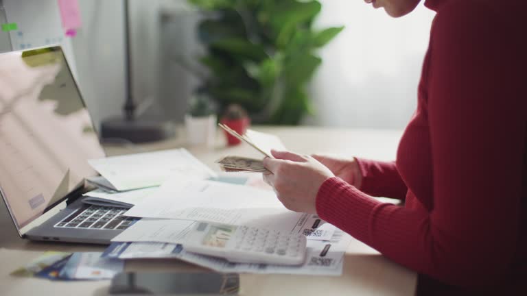 Close up female hands using calculator calculates on Home finance