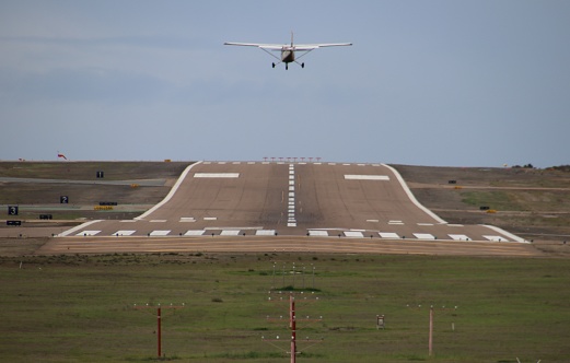 Modern private blue airplane landing at Miami International Airport.