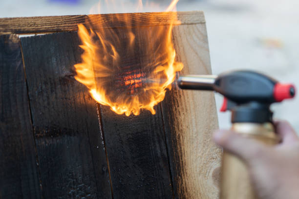 falegname professionista che utilizza la vecchia tecnica tradizionale giapponese. assi di legno in fiamme con bruciatore a gas - gas fitter immagine foto e immagini stock