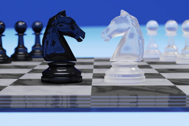 White and black horse chess encounter on a chessboard in the blue background.Chess is an strategy and intelligence board game. stock photo