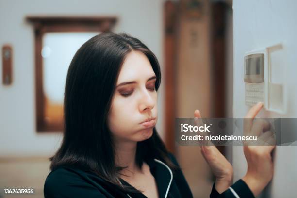 Woman Feeling Hot Setting The Room Temperature To Be Lower Stock Photo - Download Image Now