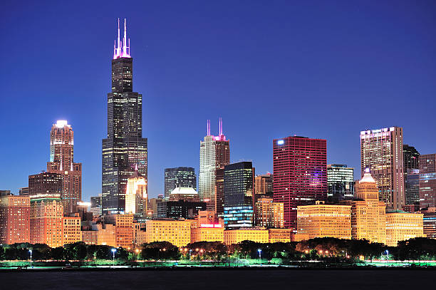 Beautiful view of the Chicago skyline at dusk Chicago city downtown urban skyline at dusk with skyscrapers over Lake Michigan with clear blue sky. willis tower stock pictures, royalty-free photos & images