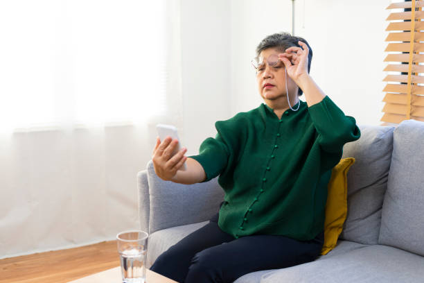 istock Elderly woman squinting while looking at smartphone screen, trying to read message. 1362641565