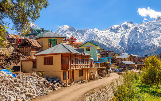 Scenic village road with residential houses and view of Kinnaur Kailash Himalaya mountain range at Kalpa, Himachal Pradesh India