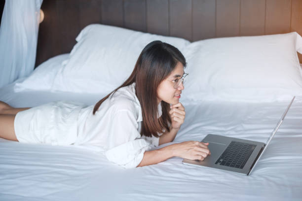 istock Happy woman using laptop for work, female meeting  online by computer notebook on bed. technology, network, work from home, lifestyle and digital communication concept 1362645870