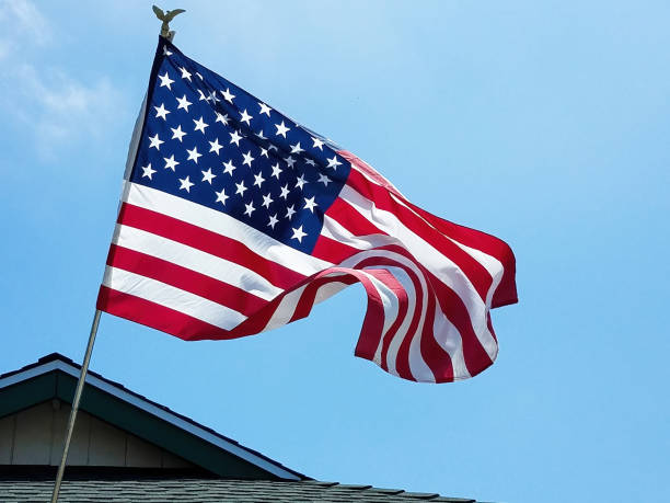 istock American Flag Flying Above Rooftop 1362647409
