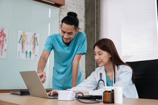 istock Two uniformed young doctors work in medical clinic office. 1362648367