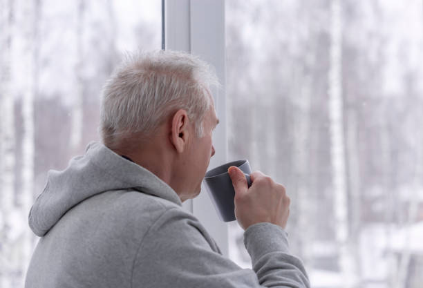 istock A man with a cup looking out the window 1362648706