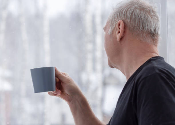 istock A man with a cup looking out the window 1362648707