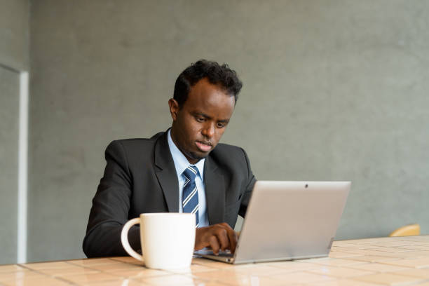 istock African businessman wearing suit and tie in coffee shop while using laptop computer 1362648724