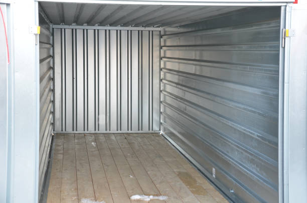 istock in the yard there is a large-capacity container with a wooden floor. serves as a garage, tool storage, or temporary home for conversion to a residential unit. open metal door 1362650997