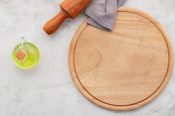 istock Empty wooden pizza platter set up on white concrete. Pizza board on white concrete background flat lay and copy space. 1362656427