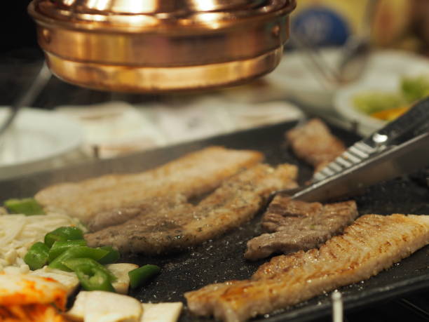 grilled pork is on the pan in Thai style, Thai buffet with pork, chicken and other meats, cooked on brass barbecue pan, pork grill, Bar-B-Q, Thai Barbecue, Korean Barbecue in Thai Style, Thai Barbecue Buffet, Thai BBQ buffet, ThaiBBQ or Yakiniku food PORK PAN cerdo a la parrilla está en la sartén en estilo tailandés, buffet tailandés con cerdo, pollo y otras carnes, cocinado en sartén de barbacoa de latón, parrilla de cerdo, bar-b-q, barbacoa tailandesa, barbacoa coreana en estilo tailandés, buffet de ba
