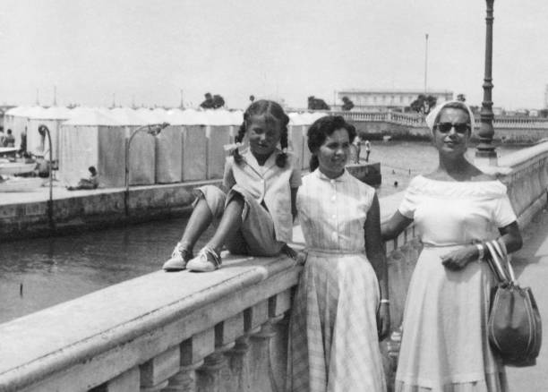 Mother and daughters in 1954 by the sea. stock photo