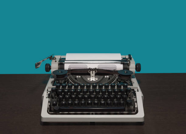 istock Typewriter 70s without top cover on wood table and blue background 1362658918
