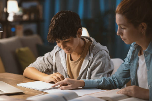 Tutor helping a student with his homework stock photo