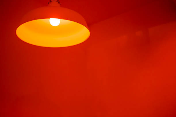 istock Ceiling lamp with yellow light with space on red background 1362659150