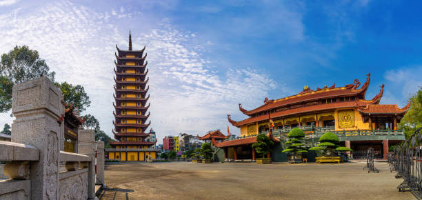 Quoc Tu Pagoda in Vietnam, Ho Chi Minh.Red tall asian temple on the blue sky background in Saigon. It is a famous pagoda in Ho Chi Minh city. Travel and religion concept. stock photo