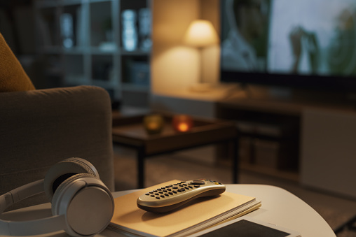 Modern living room interior with television screen in the background, selective focus