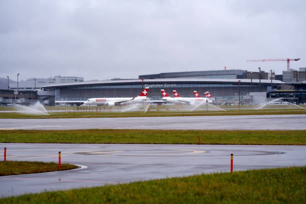 aéroport suisse zürich kloten avec fond de ciel nuageux. - runway airport sky wet photos et images de collection