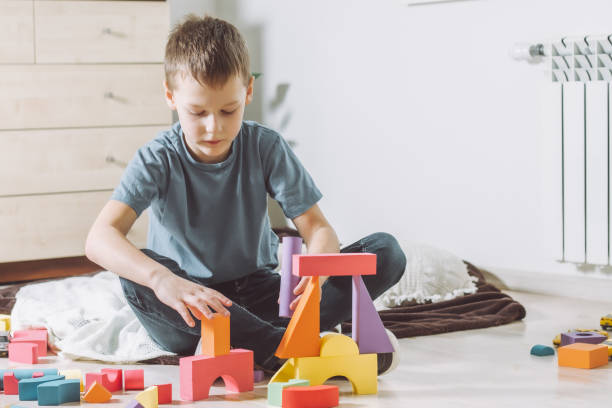 istock 7-10 boy, playing at home on the floor with geometric shapes constructor 1362668810