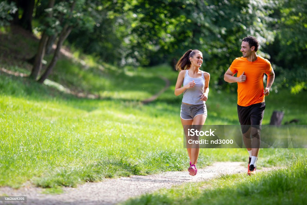 Portrait of happy fit people running together ourdoors. Couple sport healthy lifetsyle concept Portrait of happy young fit people running together ourdoors. Couple sport healthy lifetsyle concept Exercising Stock Photo