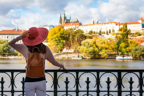 un touriste apprécie la vue sur la rivière vlatava jusqu’au château de prague - prague czech republic church skyline photos et images de collection