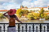A tourist enjoys the view over the Vlatava River to the castle of Prague