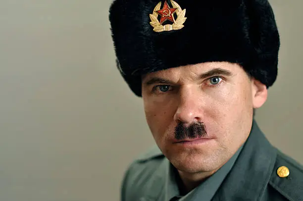 Head shot of stern Soviet military officer with narrow black mustache