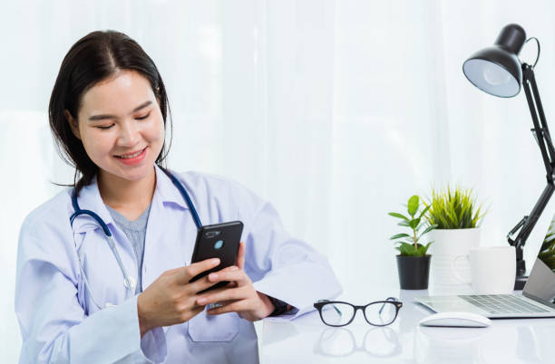 istock Doctor woman smiling using working with smart mobile phone 1362671483