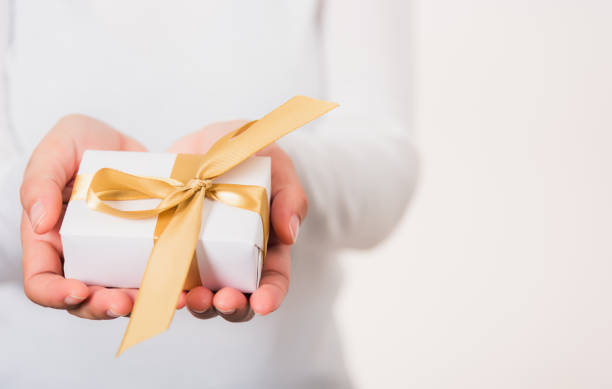 istock Female beauty hands holding small gift package box present 1362671510