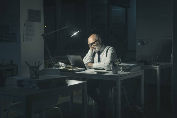 istock Bored businessman working late at night 1362677181
