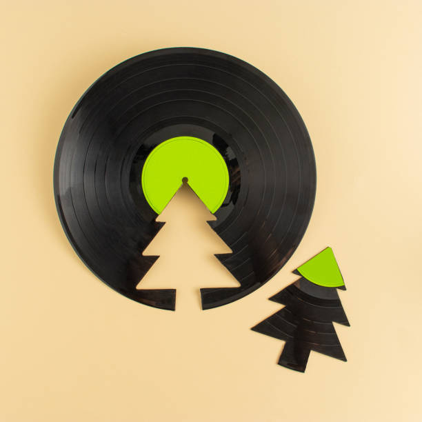 concept de noël à la mode fait d’un disque vinyle d’étiquette verte cassé et d’un arbre de noël sur fond beige avec espace de copie. fond de musique rétro créative. - christmas tree audio photos et images de collection