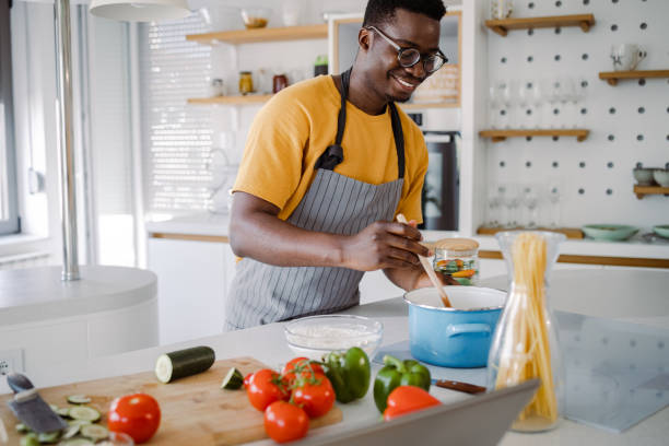 istock Young man in the kitchen, preparing a meal 1362679952