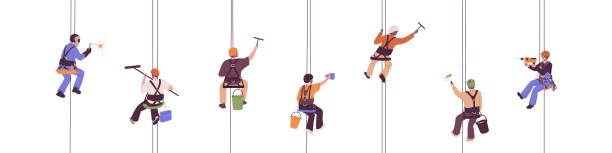 Industrial alpinists set. Workers suspended on ropes, hanging on harness. Professional climbers with equipment and tools work at height. Flat vector illustrations isolated on white background Industrial alpinists set. Workers suspended on ropes, hanging on harness. Professional climbers with equipment and tools work at height. Flat vector illustrations isolated on white background. safety harness stock illustrations