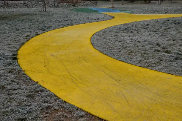 Photo of Skateboard, skating park for roller skating with a concrete cement surface painted blue and yellow. turns and training waves with obstacles. Freestyle cycling, children Protective clothing