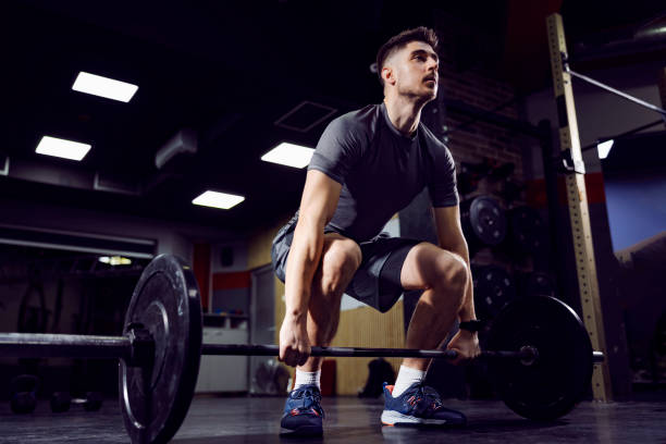 istock A muscular bodybuilder lifting barbell in gym and working out. 1362684871