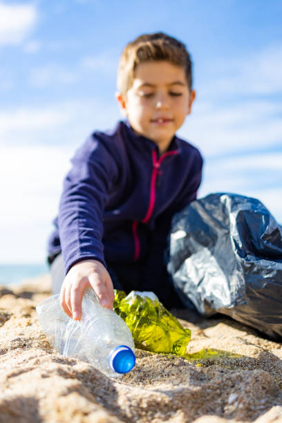 istock Little kid picking plastic on the beach. Recycling concept 1362685170